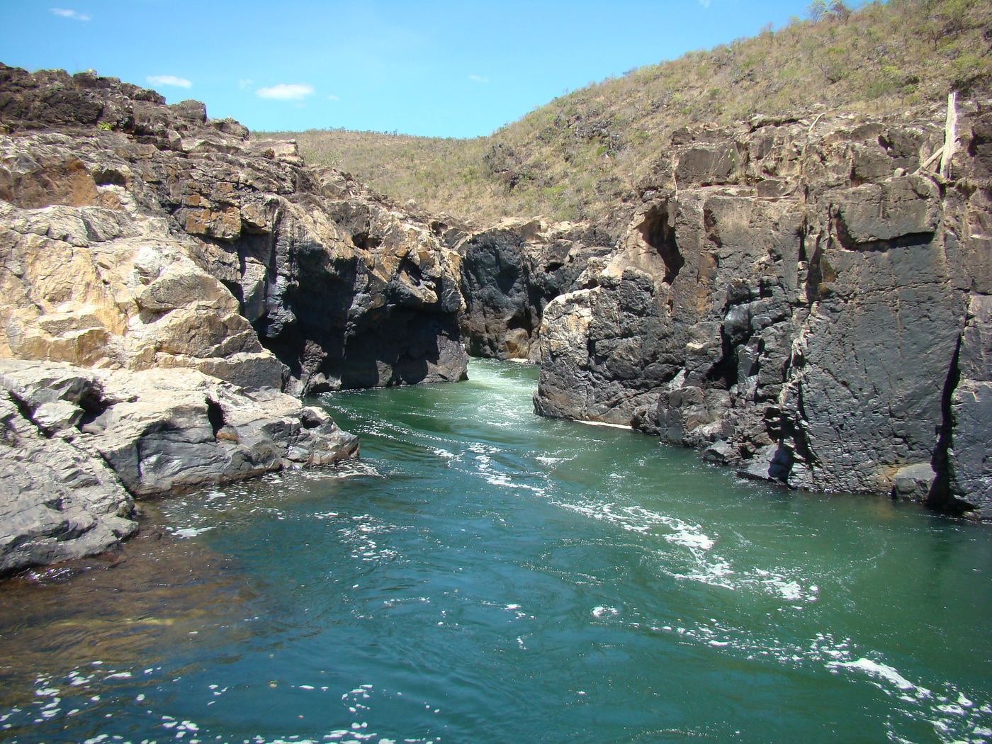 Rio de águas esmeralda entre paredões de pedra negra na Chapada dos Veadeiros, Goiás